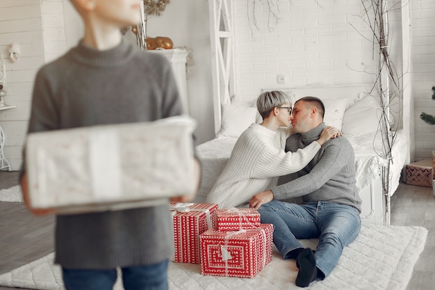 Famille dans une chambre. Petit garçon près de la décoration de Noël. Mère avec père avec fils