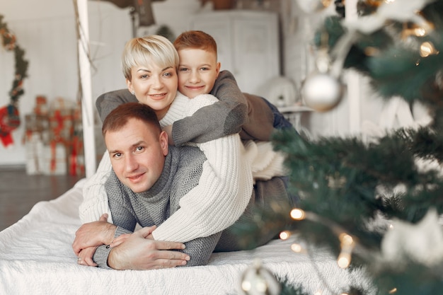 Famille dans une chambre. Petit garçon près de la décoration de Noël. Mère avec père avec fils