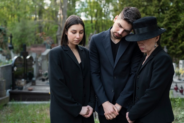 Famille en deuil ensemble au cimetière