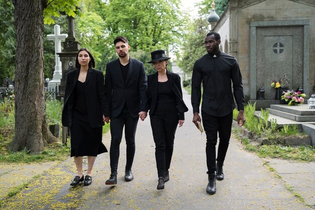 Famille en deuil avec prêtre au cimetière