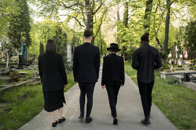 Famille en deuil vêtue de noir visitant le cimetière