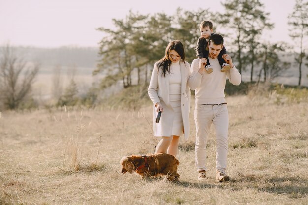 Famille élégante marchant sur un champ ensoleillé