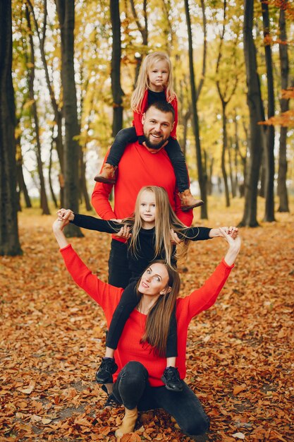 Famille avec enfants mignons dans un parc en automne