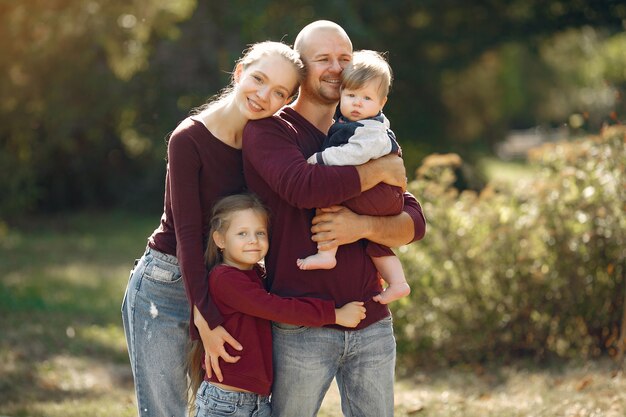 Famille avec enfants mignons dans un parc en automne