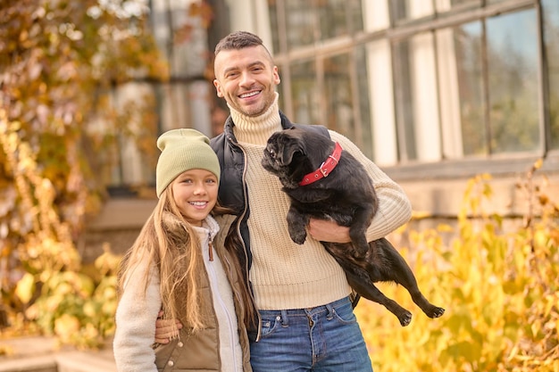 Photo gratuite famille ensemble. un homme et sa fille en promenade avec leur chien