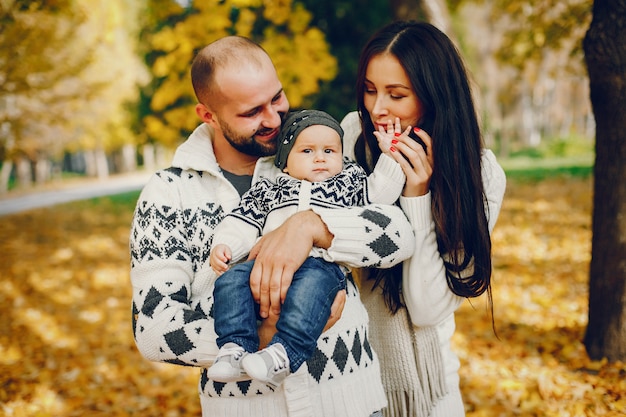 Famille avec fils dans un parc en automne