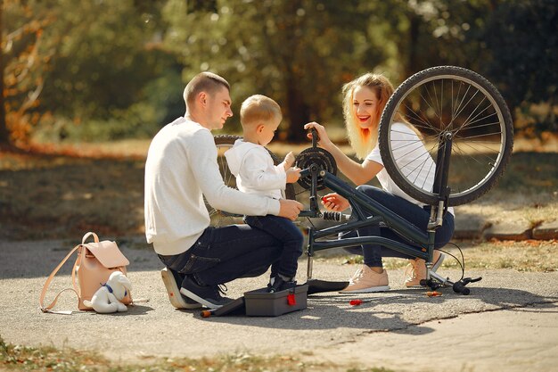 Famille avec fils réparer le vélo dans un parc
