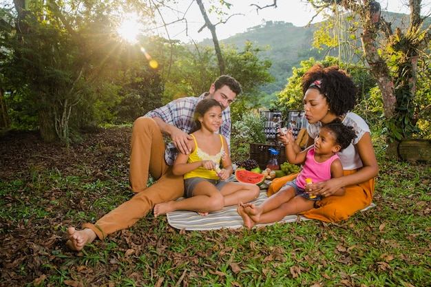 Photo gratuite famille heureuse assise dans l'herbe
