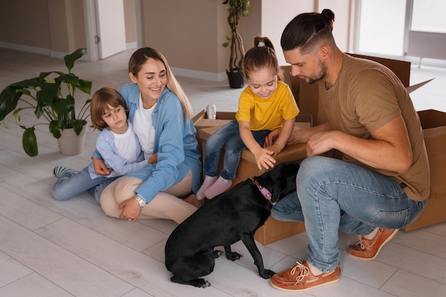 Famille heureuse avec chien emménageant dans une nouvelle maison