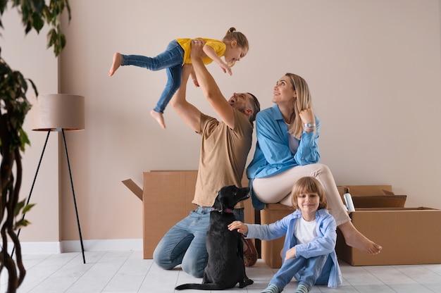 Famille heureuse avec chien emménageant dans une nouvelle maison