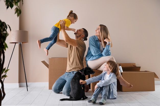 Famille heureuse avec chien emménageant dans une nouvelle maison