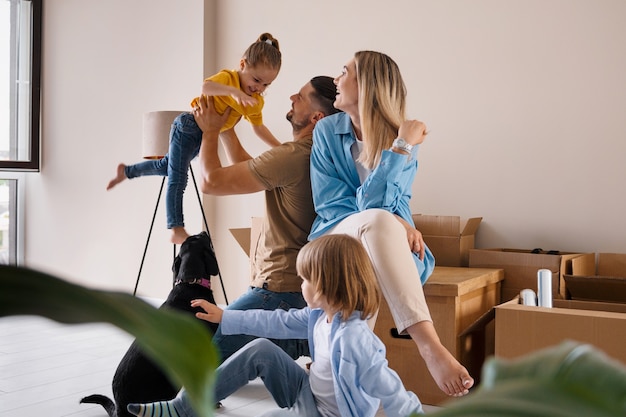 Famille heureuse avec chien emménageant dans une nouvelle maison