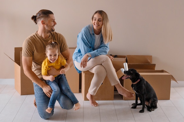 Famille heureuse avec chien emménageant dans une nouvelle maison