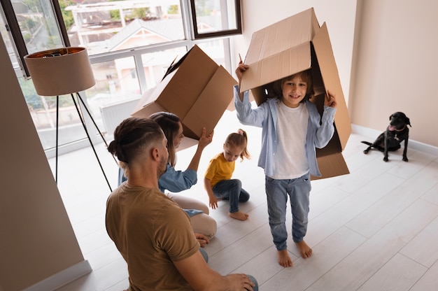 Famille heureuse avec chien emménageant dans une nouvelle maison