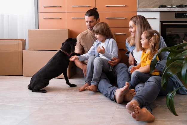 Famille heureuse avec chien emménageant dans une nouvelle maison