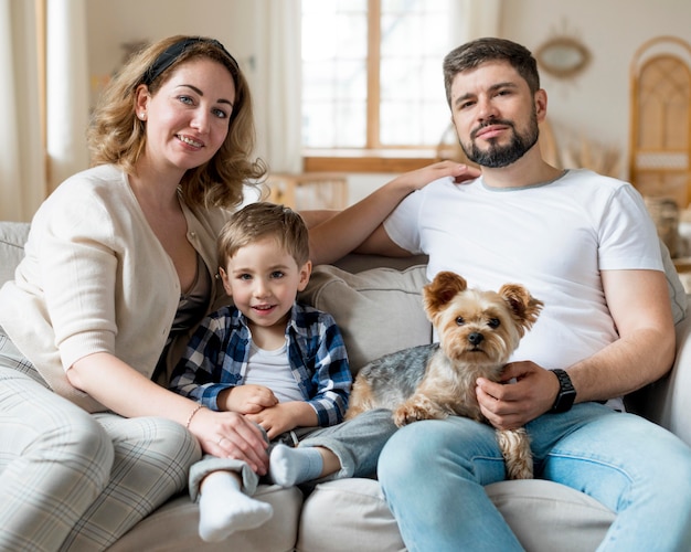 Famille heureuse et chien restant à l'intérieur