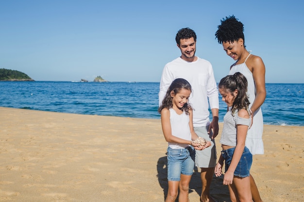 Photo gratuite famille heureuse avec un coquillage