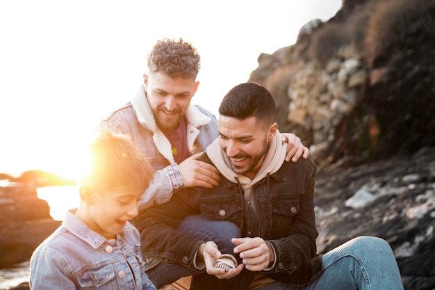 Photo gratuite famille heureuse de coup moyen au bord de la mer