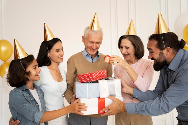 Photo gratuite famille heureuse de coup moyen avec des cadeaux