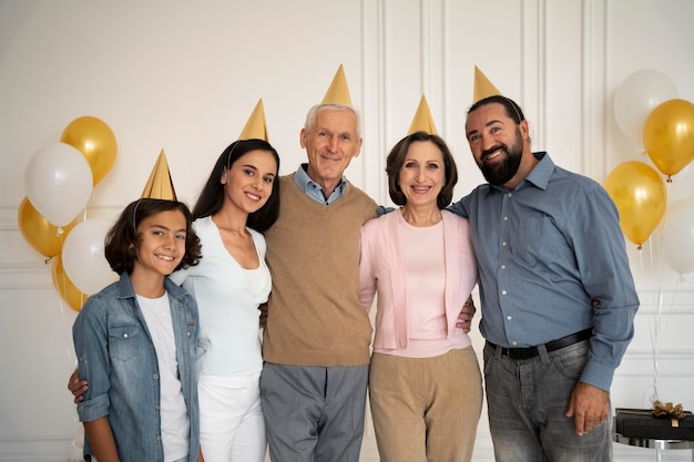 Famille heureuse de coup moyen avec des chapeaux de fête