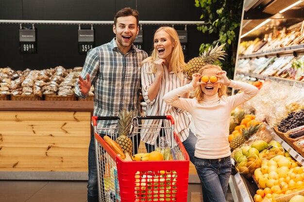 Famille heureuse, à, enfant, achat nourriture, à, épicerie