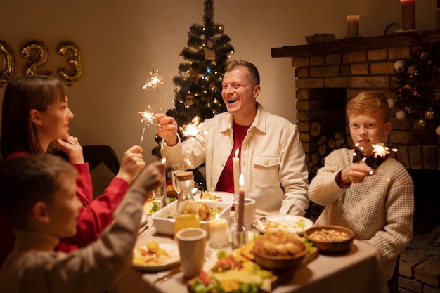 Photo gratuite famille heureuse de plan moyen avec des feux d'artifice