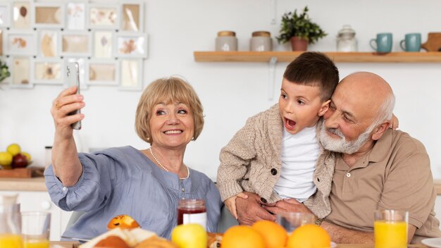 Famille heureuse de plan moyen prenant selfie