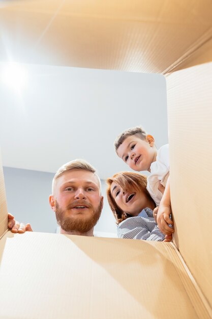 Famille heureuse vient d'emménager dans une nouvelle maison et regarde la boîte