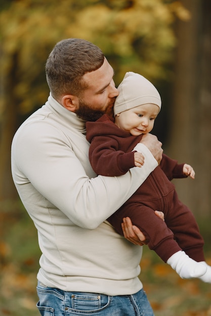 Famille avec jolie fille. Père dans un pull bbrown. Petite fille avec un papa.