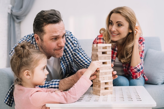 Photo gratuite famille jouant avec des blocs de bois sur la table dans le salon