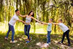 Photo gratuite famille jouant ensemble dans le parc