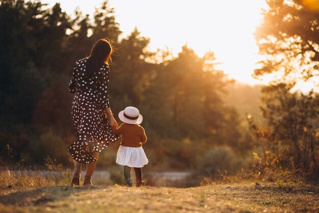 Famille avec leur petite fille dans un champ d'automne