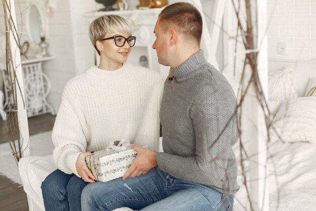 Famille à la maison. Couple près de décorations de Noël. Femme dans un pull gris.