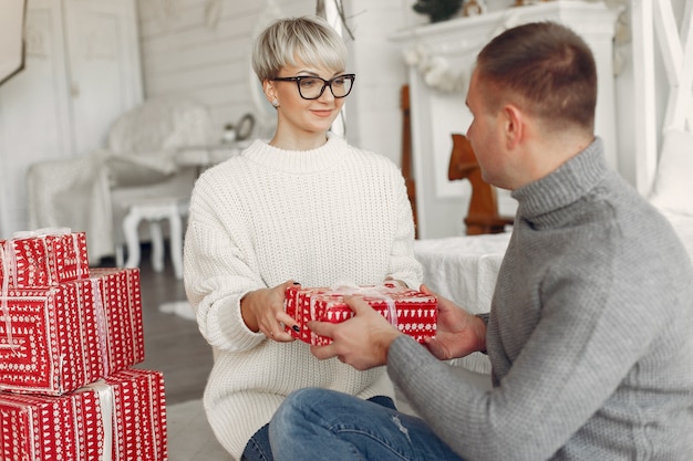 Famille à la maison. Couple près de décorations de Noël. Femme dans un pull gris.