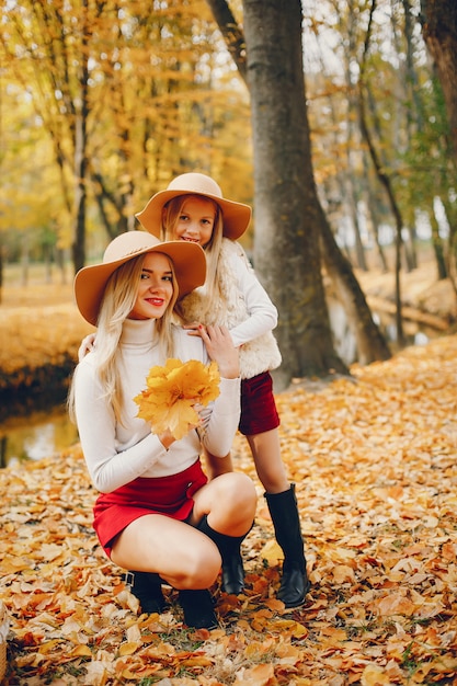 Famille mignonne et élégante dans un parc en automne