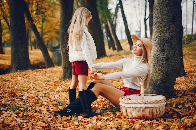 Famille mignonne et élégante dans un parc en automne