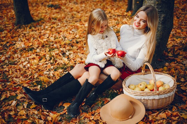 Famille mignonne et élégante dans un parc en automne