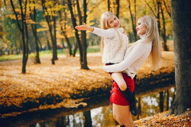 Famille mignonne et élégante dans un parc en automne