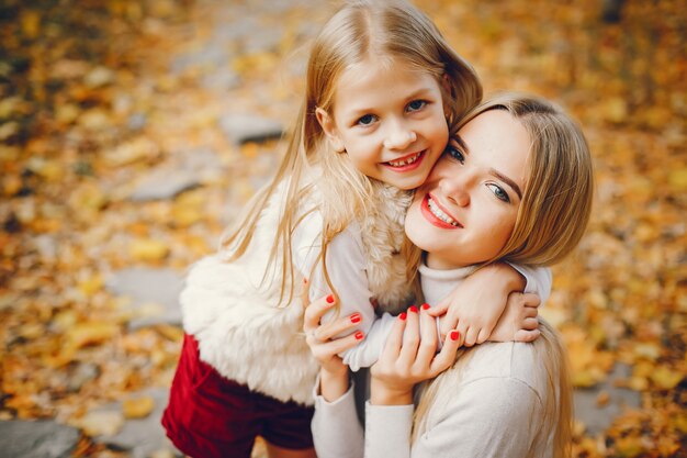 Famille mignonne et élégante dans un parc en automne