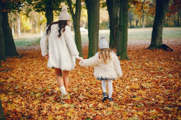 Famille mignonne et élégante dans un parc en automne