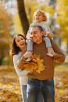 Photo gratuite famille mignonne et élégante jouant dans un champ d'automne
