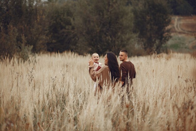 Famille mignonne et élégante jouant dans un champ