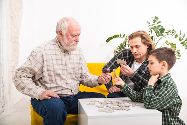 Une famille multi-générationnelle concentrée assemblant un puzzle