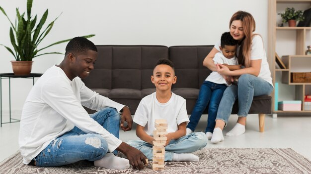 Famille multiculturelle jouant un jeu de tour en bois
