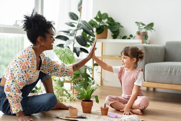 Famille multiraciale high five pendant le jardinage d'intérieur