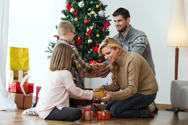 Photo gratuite famille avec noël fond d'arbre