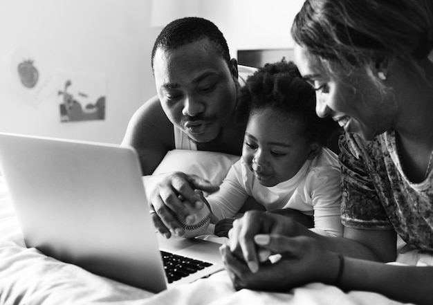 Famille noire, coucher lit, utilisation, ordinateur portable, ensemble, dans chambre