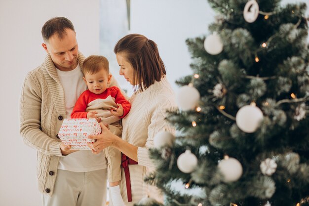 Famille avec petit fils à Noël par arbre de Noël à la maison