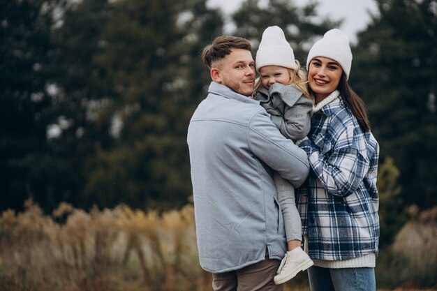 Famille avec petite fille ensemble par temps d'automne s'amusant