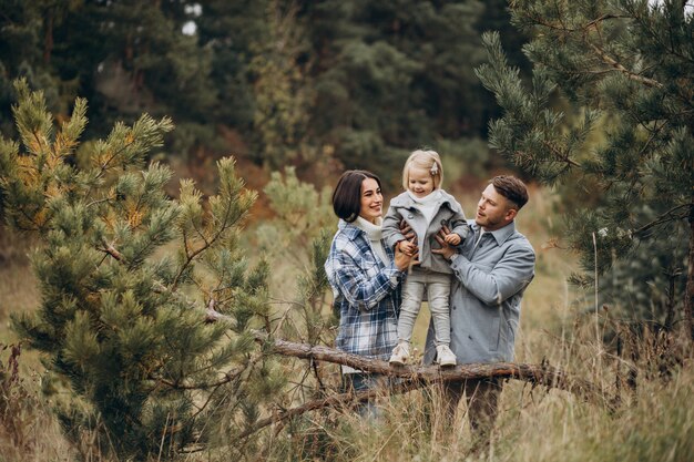 Famille avec petite fille ensemble par temps d'automne s'amusant